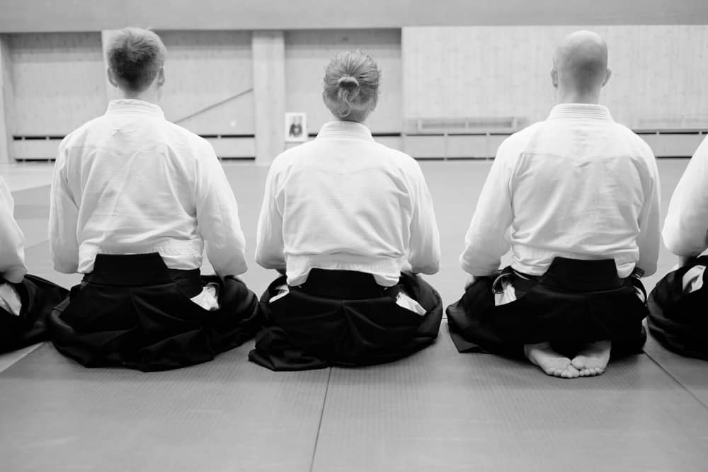 Aikido-training-participants-sit-on-a-ma