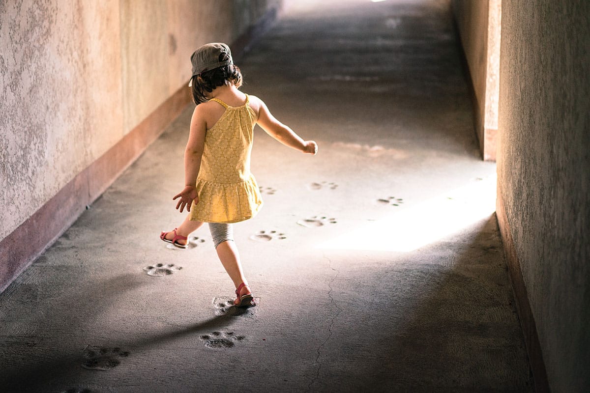 Young child following footprints in a hallway